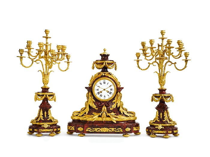 A Louis XVI style gilt bronze mounted rouge griotte marble clock garniture, Paris, 19th century. Courtesy, Sotheby's.